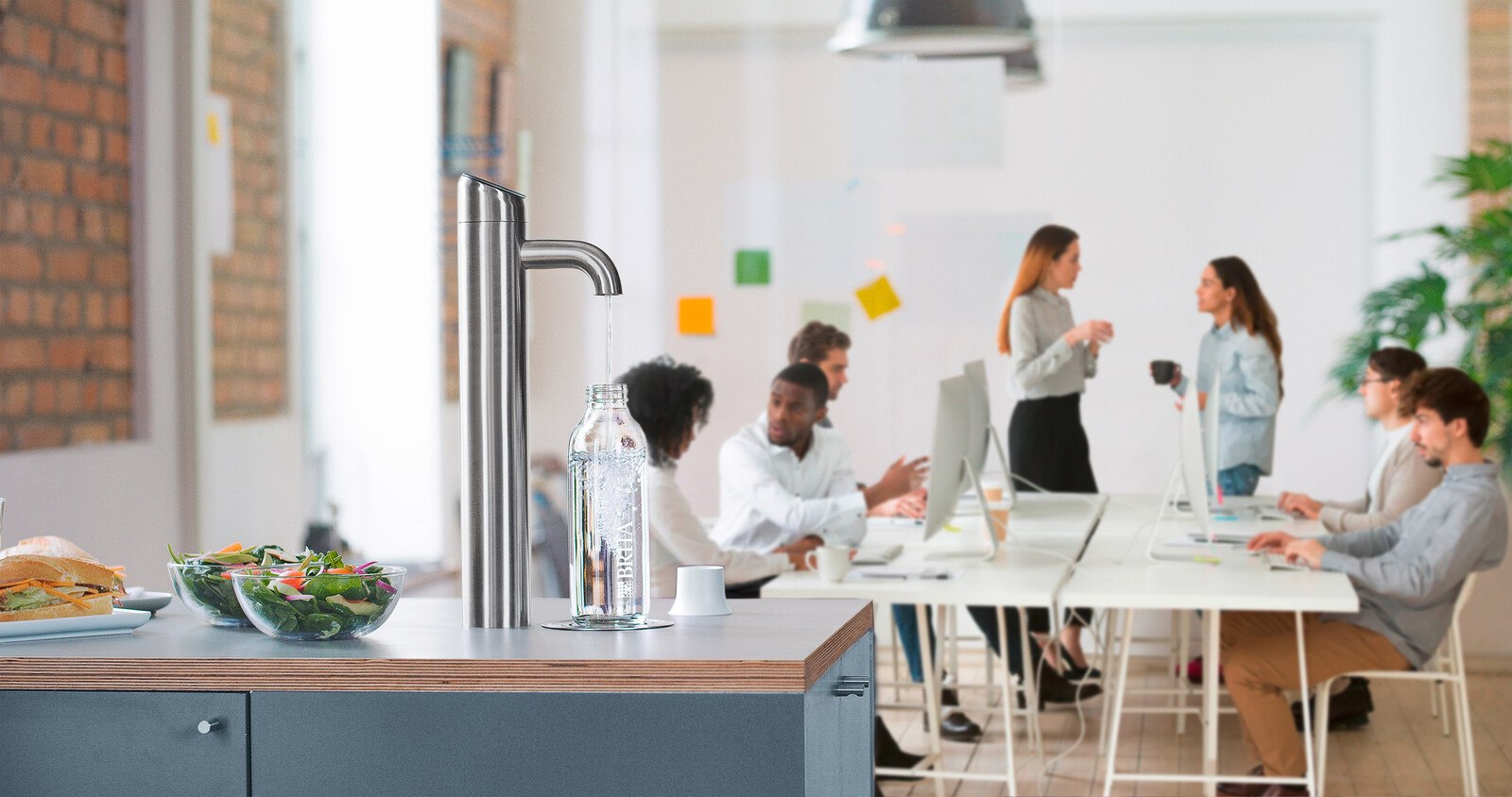 Bewusster Verzicht auf Flaschenwasser: Eine transparente Kommunikation fördert die Akzeptanz von leitungsgebundenen Wasserspendern. Das schnittige Design von BRITA lässt sie schnell zum liebgewonnen Office-Inventar werden. © BRITA