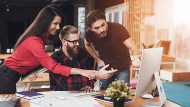 drei Personen am Schreibtisch zeigen auf Bildschirm © vadimguzhva iStock Getty Images Plus